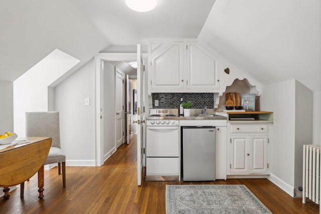 kitchen with lofted ceiling, stainless steel refrigerator, white cabinetry, white range, and radiator