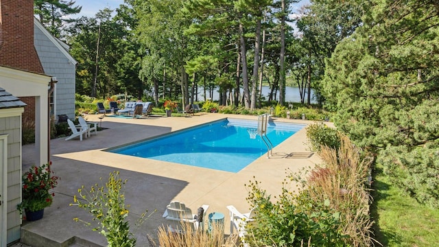 view of pool with a patio area and a water view