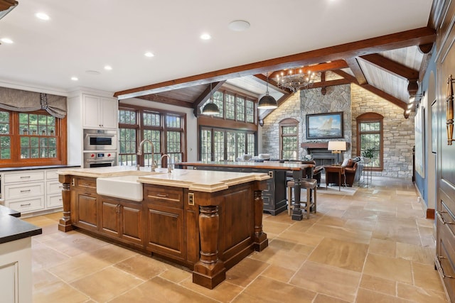 357 Salem Church Rd, Sunfish Lake, MN 55118 - kitchen featuring white cabinetry, lofted ceiling with beams, a large island with sink, and a sink