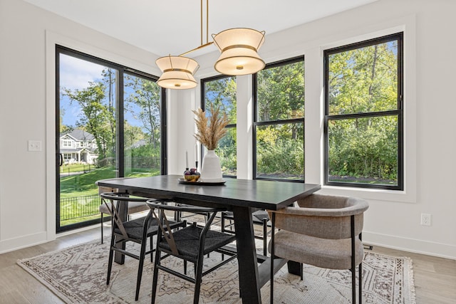 dining space with light wood-type flooring and a wealth of natural light