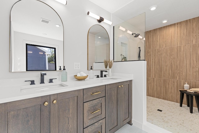 bathroom featuring tiled shower and vanity