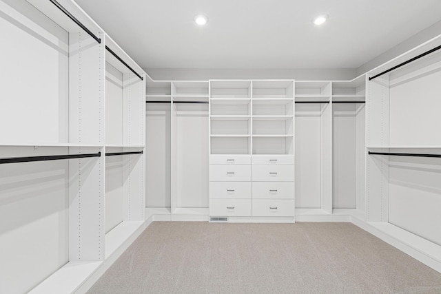 walk in closet featuring light colored carpet