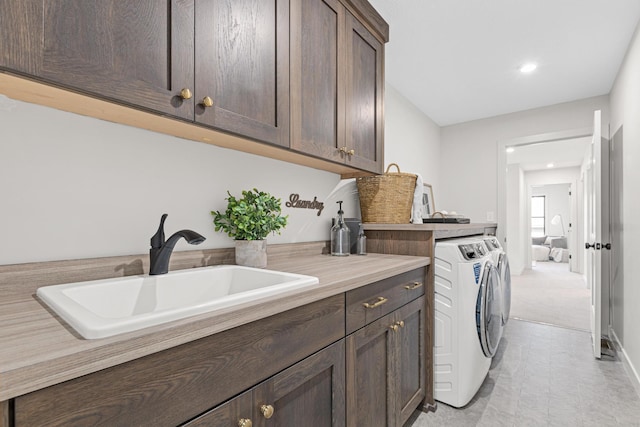 laundry area with sink, cabinets, and separate washer and dryer