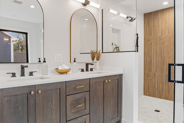 bathroom with vanity and a tile shower