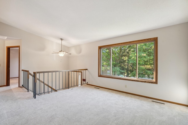 carpeted empty room featuring ceiling fan and lofted ceiling