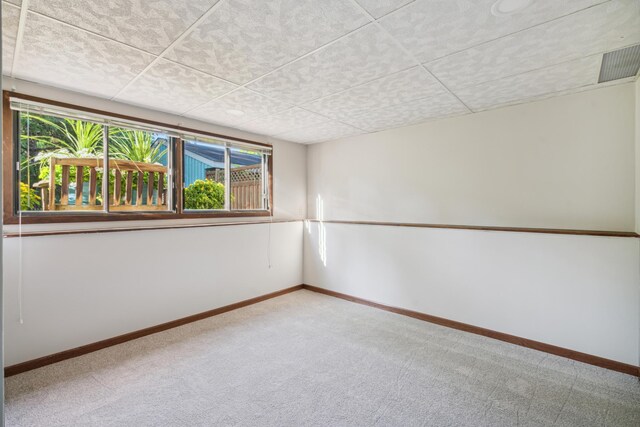 unfurnished room with a drop ceiling and carpet floors