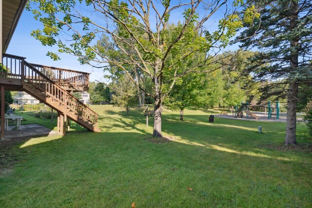 view of yard featuring a playground and a wooden deck