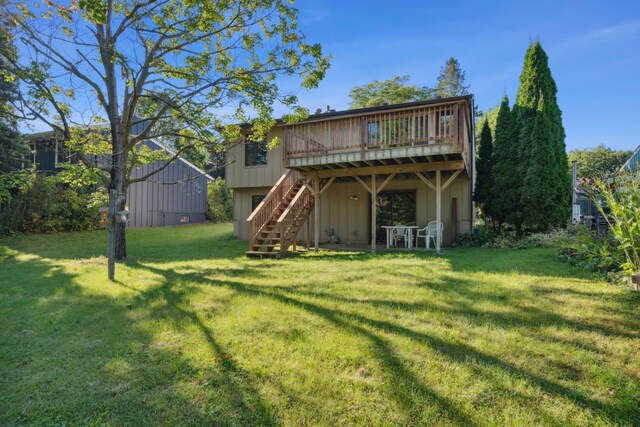 rear view of house with a yard and a wooden deck