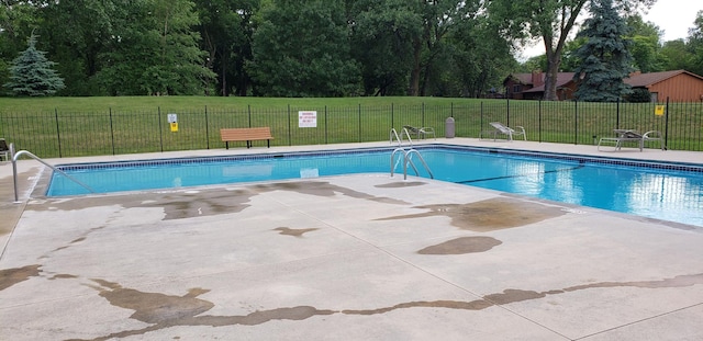 view of swimming pool featuring a patio area and a yard