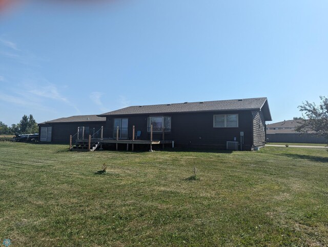 back of property featuring a yard, central AC unit, and a deck