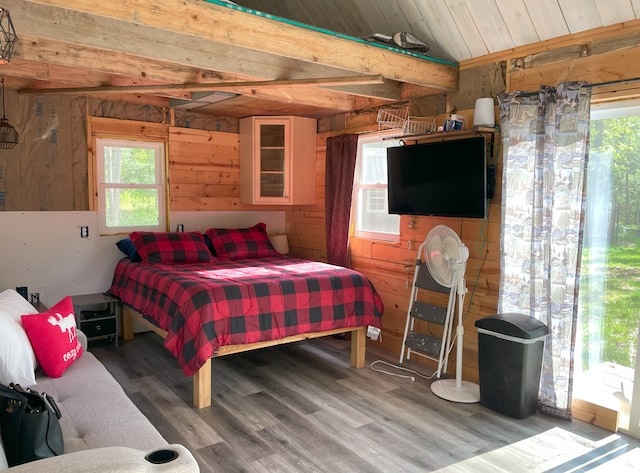 bedroom featuring hardwood / wood-style floors, wood ceiling, wooden walls, and access to exterior