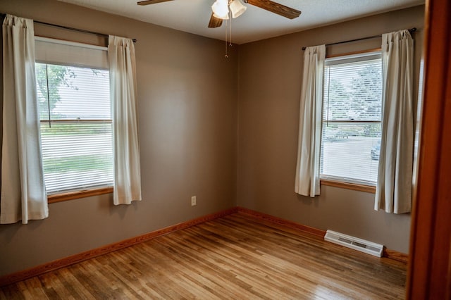 unfurnished room with ceiling fan, a healthy amount of sunlight, and light wood-type flooring