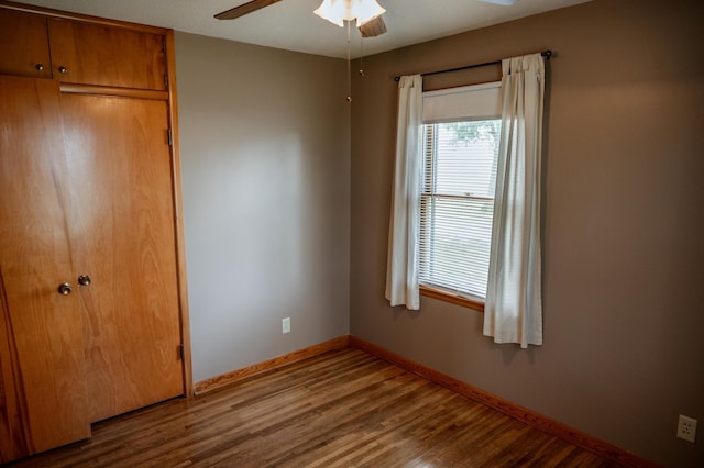 unfurnished bedroom featuring ceiling fan, wood-type flooring, and a closet