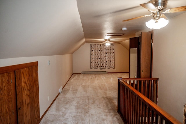 additional living space with baseboard heating, light colored carpet, and vaulted ceiling