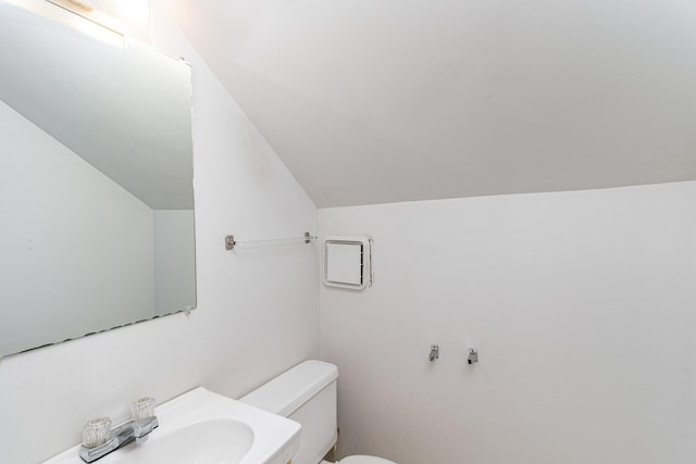 bathroom with sink, lofted ceiling, and toilet