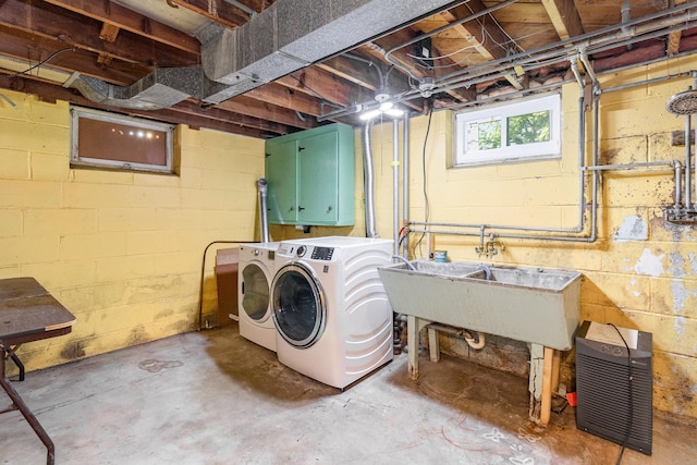 clothes washing area featuring separate washer and dryer and sink