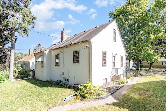 view of side of home with a yard