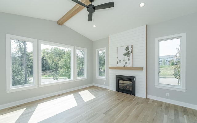 unfurnished living room with light hardwood / wood-style flooring, ceiling fan, lofted ceiling with beams, and a fireplace