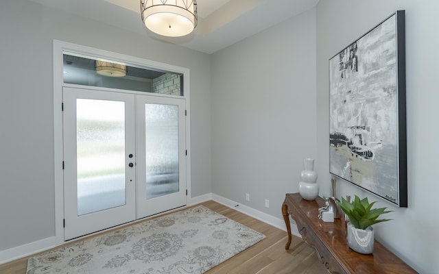 foyer featuring light wood-type flooring and french doors