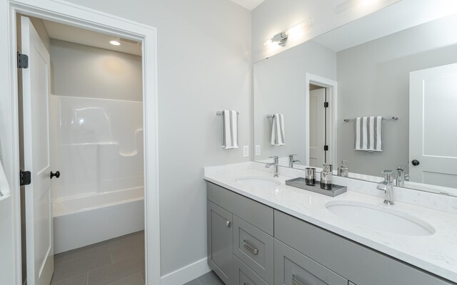 bathroom featuring tile patterned floors,  shower combination, and vanity