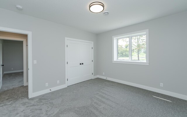 unfurnished bedroom featuring light colored carpet and a closet