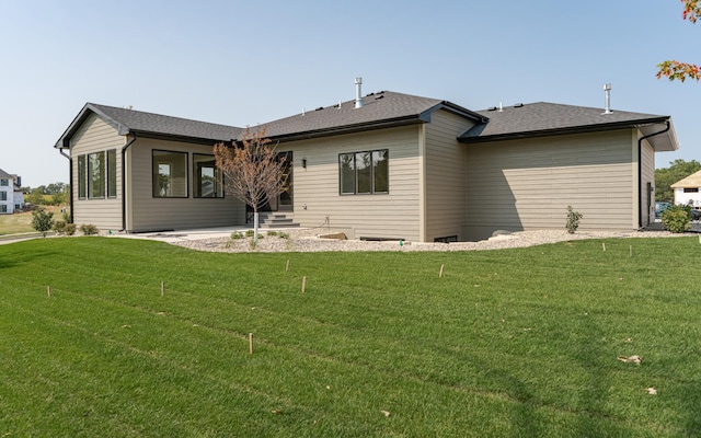 rear view of property featuring a lawn