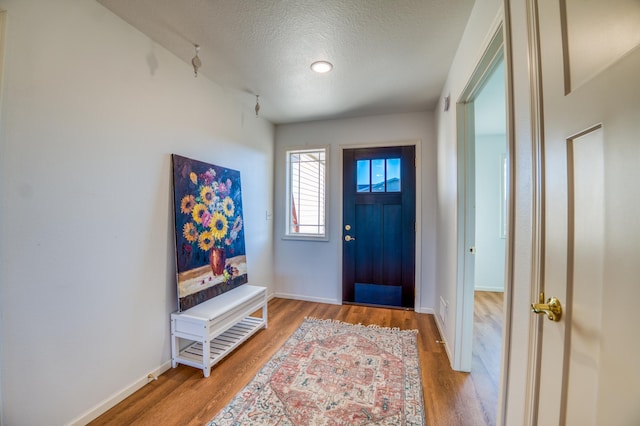 entryway with hardwood / wood-style floors and a textured ceiling