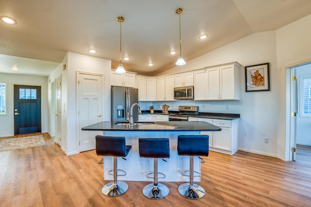 kitchen featuring white cabinetry, stainless steel appliances, a kitchen breakfast bar, and sink