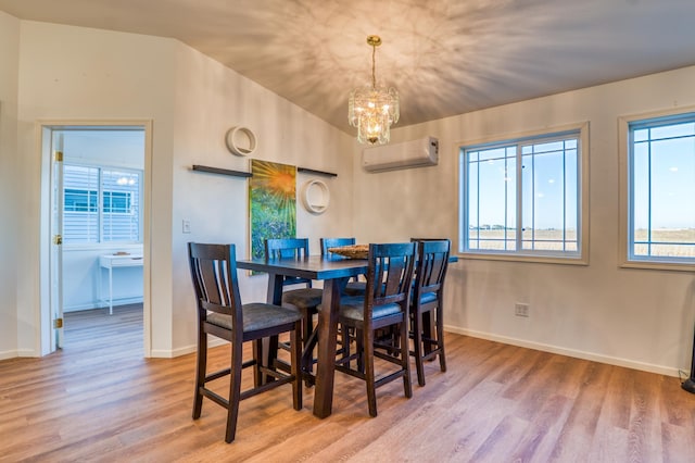 dining area featuring an inviting chandelier, plenty of natural light, a wall mounted AC, and light wood-type flooring