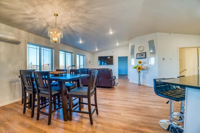 dining space featuring a notable chandelier, lofted ceiling, light hardwood / wood-style floors, and an AC wall unit