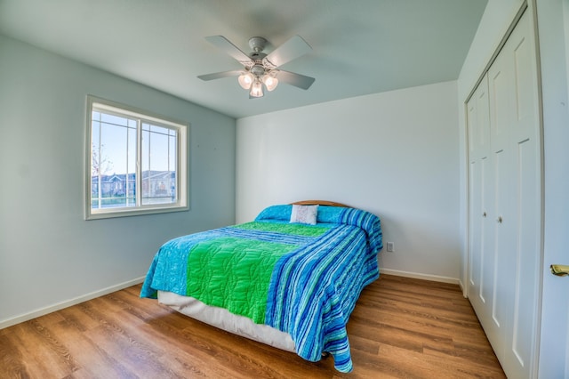 bedroom with wood-type flooring, ceiling fan, and a closet