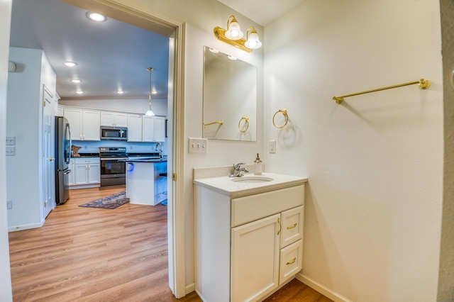 bathroom with vanity, lofted ceiling, and hardwood / wood-style floors