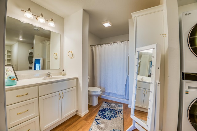 bathroom featuring a shower with curtain, stacked washer / drying machine, wood-type flooring, and vanity