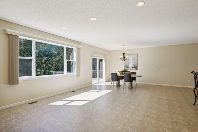 interior space featuring a textured ceiling and an inviting chandelier