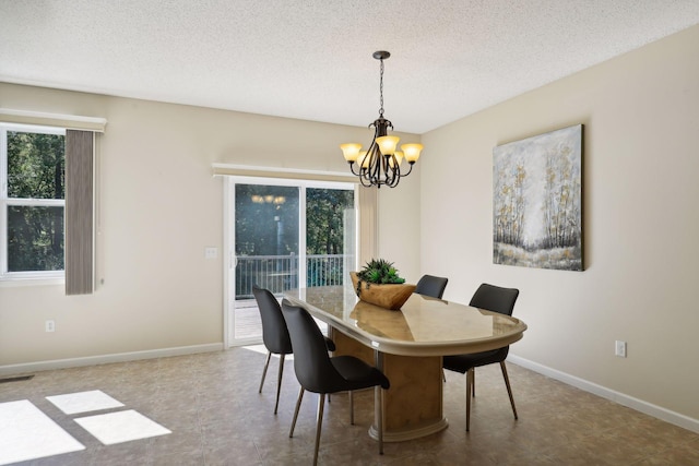 dining space featuring a chandelier, a textured ceiling, and tile patterned flooring