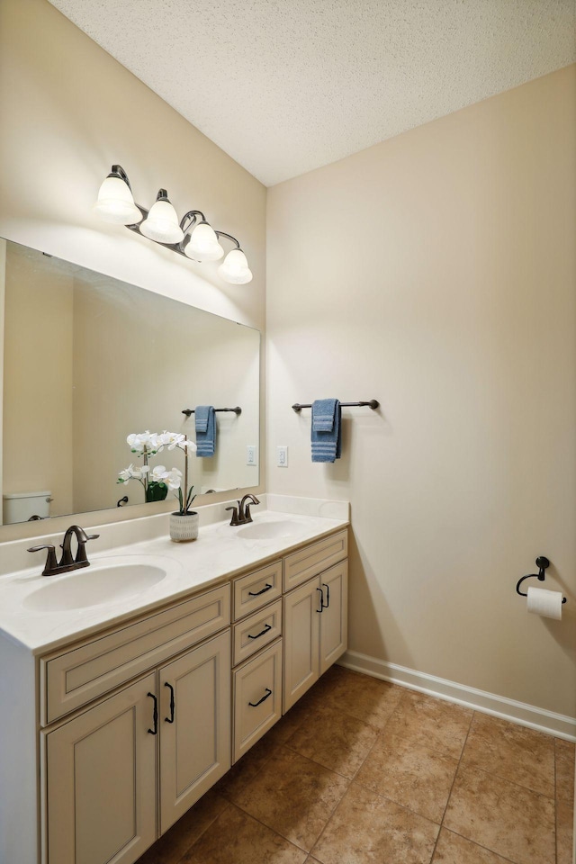 bathroom with vanity, tile patterned floors, a textured ceiling, and toilet