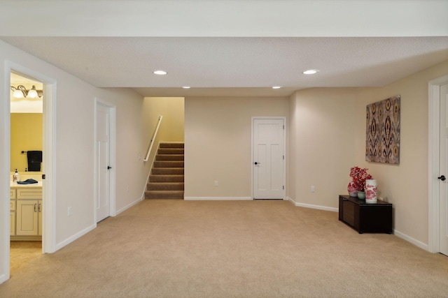 basement featuring a textured ceiling and light carpet