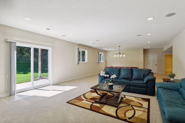 carpeted living room with a textured ceiling and a notable chandelier