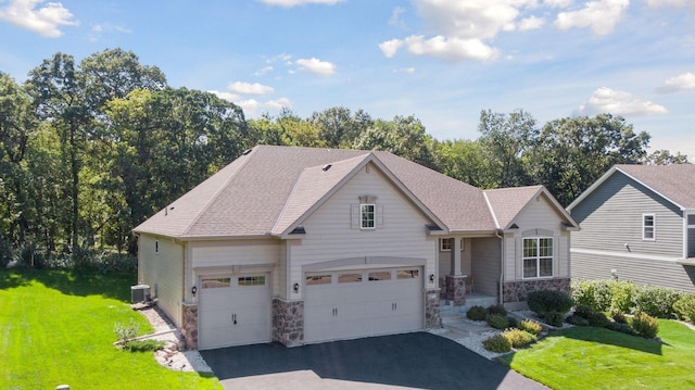 view of front of house featuring a front lawn, a garage, and central AC unit