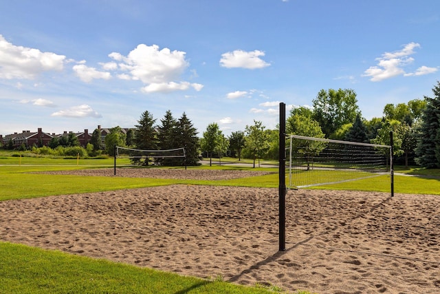 view of property's community with volleyball court and a yard