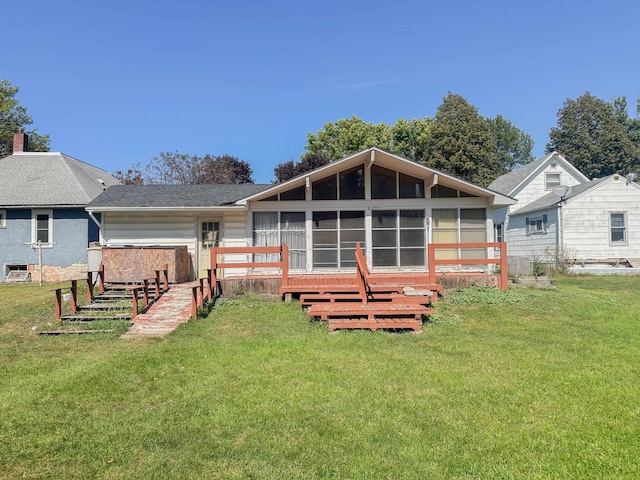 rear view of house with a sunroom and a yard