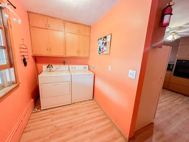 clothes washing area featuring ceiling fan, cabinets, light wood-type flooring, and washer and clothes dryer