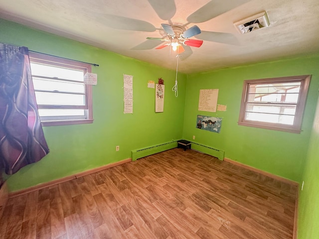 unfurnished room featuring ceiling fan, baseboard heating, and wood-type flooring