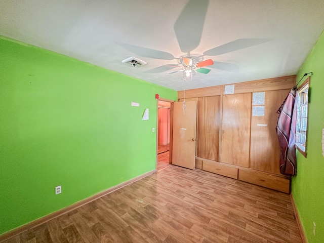 unfurnished bedroom with ceiling fan and hardwood / wood-style floors