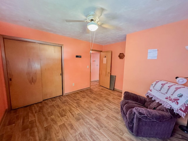 living area with light wood-type flooring and ceiling fan