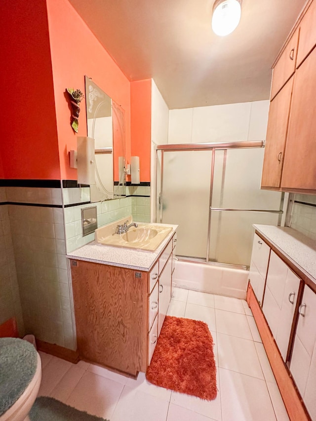 full bathroom featuring tile patterned floors, enclosed tub / shower combo, vanity, and toilet