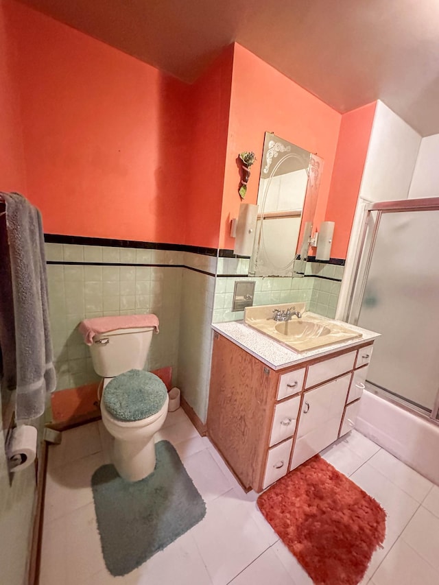 full bathroom with tile walls, vanity, toilet, and tile patterned floors