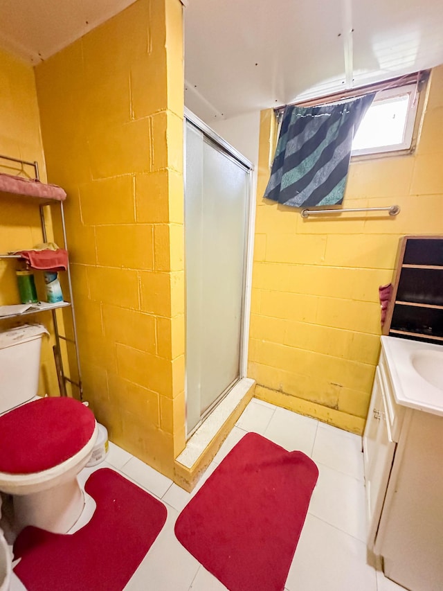 bathroom featuring vanity, a shower with shower door, toilet, and tile patterned flooring