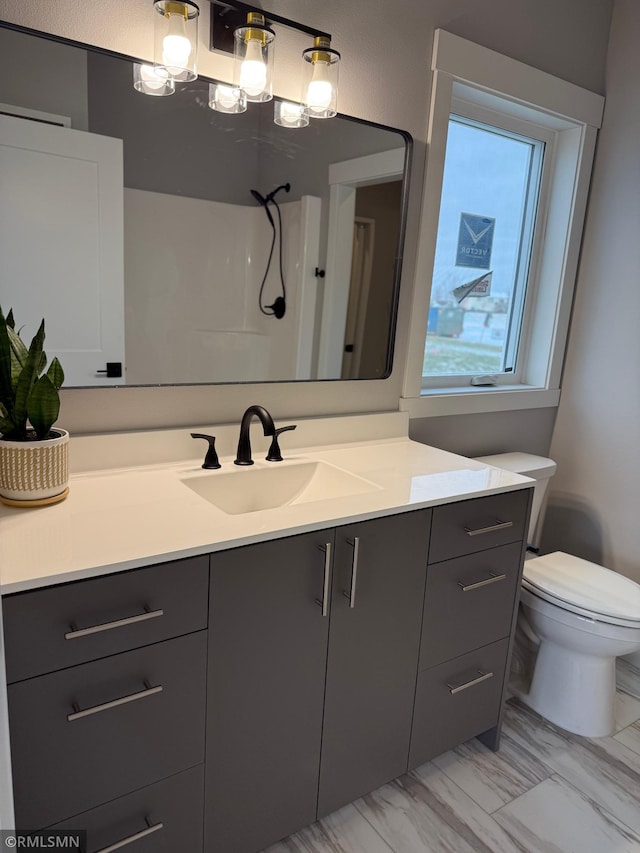 bathroom featuring vanity, toilet, and a shower