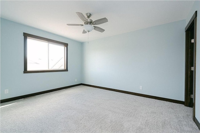 empty room with ceiling fan and light carpet